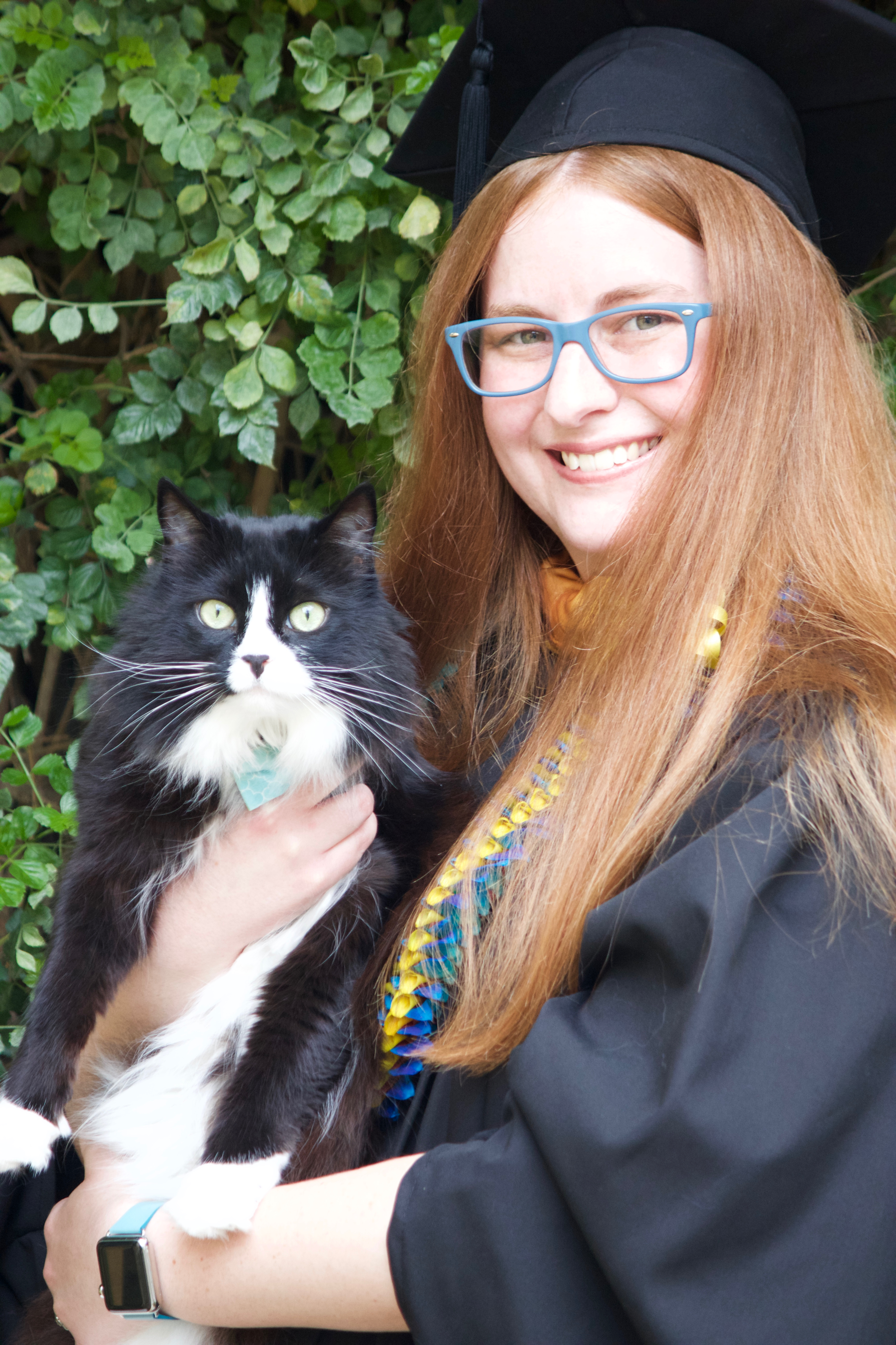 Emilie and her cat pose for a graduation photo